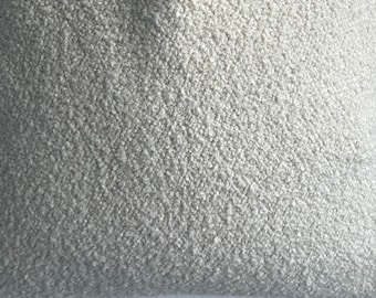 May include: Close-up of a soft, gray, fuzzy fabric. The fabric has a textured, fluffy surface.
