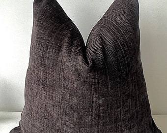 May include: A dark brown throw pillow with a textured fabric. The pillow is square shaped and has a simple design.