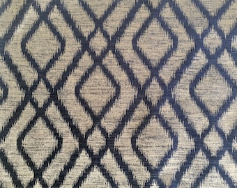 May include: A close-up of a fabric with a geometric pattern. The pattern is made up of diamonds and squares in shades of blue and beige.