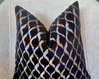 May include: A black velvet pillow with a geometric pattern in gold and silver thread. The pattern is a series of interlocking diamonds and curves.