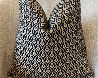 May include: A black and gold patterned throw pillow with a geometric design. The pillow is made of a soft, textured fabric.