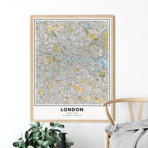 Peut inclure: Une carte encadr&eacute;e de Londres, en Angleterre, avec une rivi&egrave;re bleu clair et des zones jaunes en surbrillance. La carte est imprim&eacute;e sur du papier blanc et a un cadre en bois. Le texte "LONDON ENGLAND 51.500&deg;N / 0.009&deg;W" est imprim&eacute; en bas de la carte.