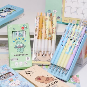 Juego de 5 bolígrafos retráctiles de secado rápido con dibujos animados para estudiantes y exámenes, 0,5 mm, 6 diseños por juego, tinta negra y azul.