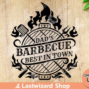 Könnte beinhalten: Schwarzweißes Grafikdesign eines Grills mit Flammen, einem Spatel und einer Grillgabel. Der Text lautet "Dads Barbecue, das Beste in der Stadt".