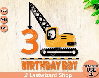 May include: A yellow construction crane with black details lifts a large orange number 3. The crane is on a black and yellow striped surface with the text "Birthday Boy" in orange letters.