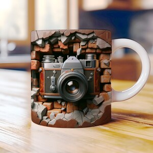 May include: A white ceramic mug with a vintage camera design. The camera is depicted as breaking through a brick wall, with the lens facing the viewer.