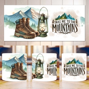 May include: Watercolor design featuring brown hiking boots, a green lantern, and mountain scenery. The text "TAKE ME TO THE MOUNTAINS" is also included. The design is printed on a white mug, perfect for outdoor enthusiasts.