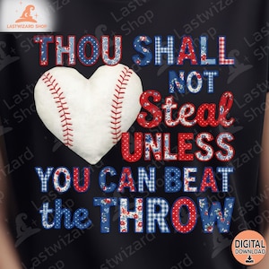 Puede incluir: Camiseta negra con un diseño de béisbol. El texto dice "THOU SHALL NOT STEAL UNLESS YOU CAN BEAT THE THROW" en patrones rojos, blancos y azules. Una pelota de béisbol en forma de corazón está en el centro.