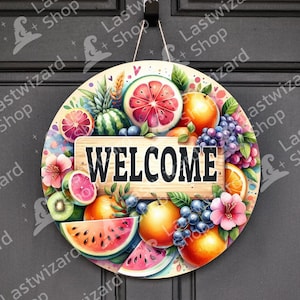 Puede incluir: Un letrero redondo de madera con un diseño de frutas colorido y la palabra "WELCOME" en negro. El letrero presenta ilustraciones de sandía, naranjas, uvas, kiwi y otras frutas, con flores rosas y moradas.