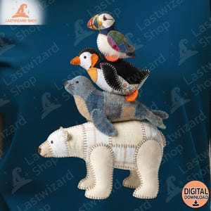 Puede incluir: Una pila de juguetes de animales de tela hechos a mano. Un oso polar está en la parte inferior, seguido de una foca, un pingüino y un frailecillo. Los juguetes están hechos de varias telas y cosidos con costuras visibles.