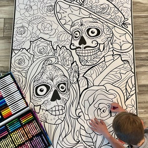 K&ouml;nnte beinhalten: Eine gro&szlig;e Malvorlage mit einem Paar Skeletten, die in traditioneller Kleidung des D&iacute;a de Muertos gekleidet sind. Die Skelette sind von Blumen und komplizierten Mustern umgeben. Die Vorlage ist bereit, mit Buntstiften oder Markern ausgemalt zu werden.