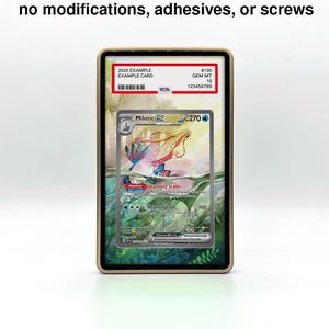 May include: A graded Pok&eacute;mon card in a protective case. The card features a Milotic character with a colorful aquatic background. The case has a gold-colored frame and the text "100% damage-free" is visible at the top.