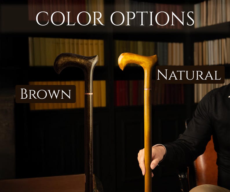May include: The image displays two wooden walking canes, one brown and one natural. The canes have curved handles and are presented against a backdrop of bookshelves. The text "COLOR OPTIONS" is at the top, with "BROWN" and "NATURAL" labeling each cane.