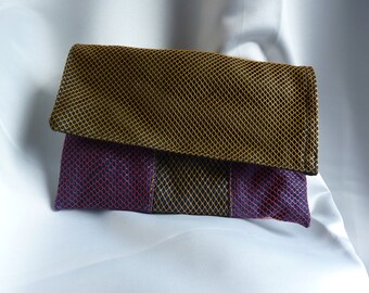 May include: A small, rectangular clutch purse with a black, yellow, and burgundy geometric pattern. The purse has a flap closure.