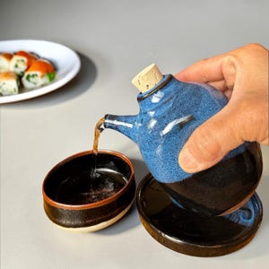 Ceramic Soy Sauce Dispenser, Oil Cruet in a Blue/Black Glaze & Cork Top with Thumb Indent and A Matching Drip Plate/Saucer.
