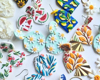 May include: Assortment of handmade polymer clay earrings featuring various designs, including watermelon slices, floral patterns, and abstract shapes. The earrings are colorful and vibrant, with a variety of textures and details.