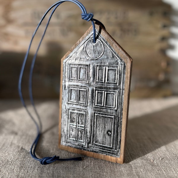 Wooden house for hanging with window front made of metal foil