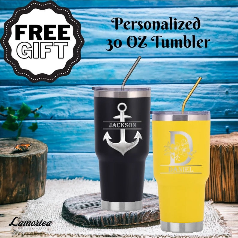 K&ouml;nnte beinhalten: Zwei personalisierte Becher mit 30 Unzen. Einer ist schwarz mit einem silbernen Anker und dem Namen "JACKSON" darauf. Der andere ist gelb mit einem Blumendesign und dem Namen "DANIEL" darauf.