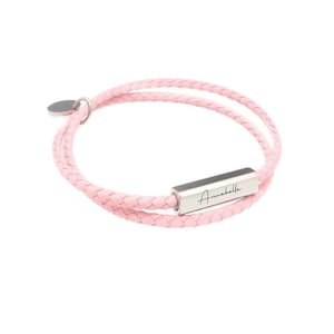 May include: A pink leather bracelet with a silver bar that says "Annabella" in cursive.