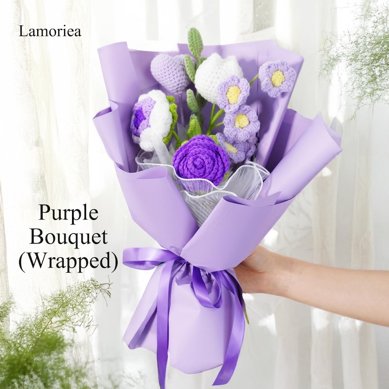 May include: A purple crocheted flower bouquet wrapped in lavender paper with a matching ribbon. The bouquet includes white and purple flowers.