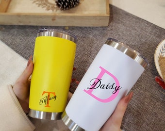 May include: Two stainless steel tumblers with personalized names. The yellow tumbler has the name "Tiffany" with an orange "T". The white tumbler has the name "Daisy" with a pink "D".