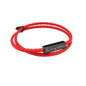 May include: Red leather bracelet with a black metal bar engraved with the text "You are my sunshine".