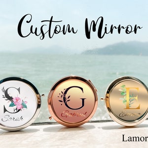 Pode incluir: Três espelhos compactos redondos com iniciais e nomes personalizados. Os espelhos são prateados, ouro rosa e ouro. Os nomes são Sarah, Gabriel e Emma.