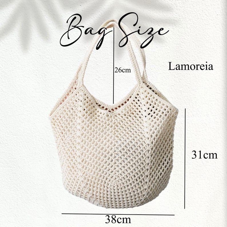 Peut inclure: Sac fourre-tout en crochet blanc cass&eacute; avec une ouverture en forme de V. Le sac mesure 38 cm de large, 31 cm de haut et les anses mesurent 26 cm de long. Le texte "Bag Size" et "Lamoreia" sont visibles. Le sac a un design ouvert tiss&eacute;.