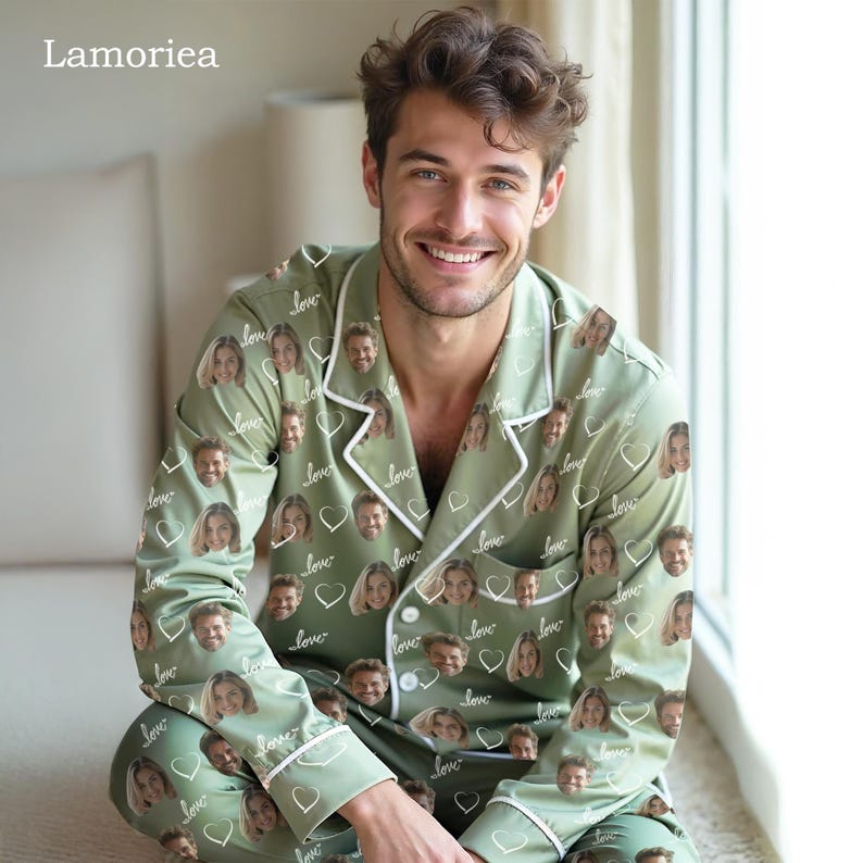 May include: Sage green pajama set with a white trim, featuring a repeating pattern of faces, hearts, and the word "love." The long-sleeved top has a notched collar and button-down front. The pajama bottoms are also visible.
