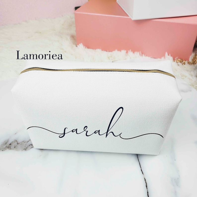 May include: White canvas zippered pouch with a gold zipper and the name "sarah" written in black cursive script.