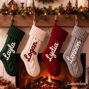 Peut inclure: Quatre chaussettes de Noël en tricot torsadé suspendues en rangée. La première est vert foncé avec le texte blanc Layla, la deuxième est crème avec le texte rouge Logan, la troisième est rouge avec le texte blanc Lydia et la quatrième est grise avec le texte blanc Lennon.