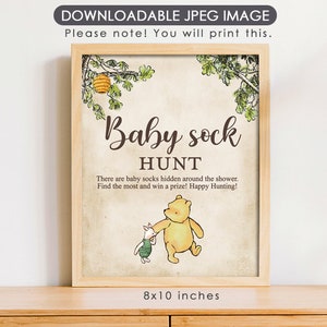 May include: Printable Winnie the Pooh themed baby shower game sign. The sign is beige with brown text that reads "Baby Sock Hunt". There are baby socks hidden around the shower. Find the most and win a prize! Happy Hunting!"  The sign features Winnie the Pooh and Piglet. The sign is 8x10 inches.