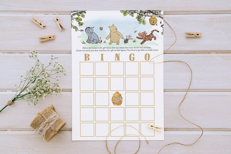 Pode incluir: Um cart&atilde;o de bingo com tema do Winnie the Pooh com um pote de mel no quadrado central. O cart&atilde;o tem 25 quadrados com espa&ccedil;os em branco para que os jogadores os preencham com presentes. O texto "Preencha as caixas com os presentes que voc&ecirc; acha que a futura mam&atilde;e receber&aacute;. Marque cada caixa que coincidir com o presente &agrave; medida que ele &eacute; aberto. O primeiro a conseguir cinco em uma linha ganha!" est&aacute; impresso no topo do cart&atilde;o.