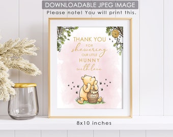 May include: A printable 8x10 inch thank you card featuring Winnie the Pooh holding a jar of honey. The card has a pink watercolour background with gold text that reads "Thank you for showering our little Hunny with love".