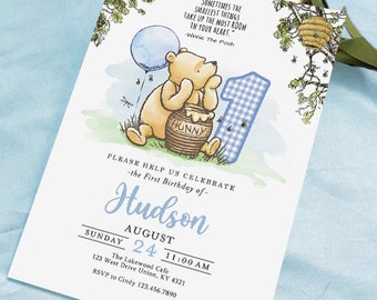 May include: Winnie the Pooh themed first birthday invitation with a blue and white checkered number one, a blue balloon, and a honey pot. The invitation includes the text "Please help us celebrate - the first birthday of - Hudson August 24 11:00 AM The Lakewood Cafe 123 West Drive Union, KY 4321 RSVP to Cindy 123.456.7890"