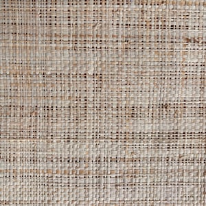 May include: Close-up of a woven natural fiber material. The texture is a tight weave of light brown and beige strands, creating a grid-like pattern. The material appears to be a natural fiber, possibly used for home decor or crafts.