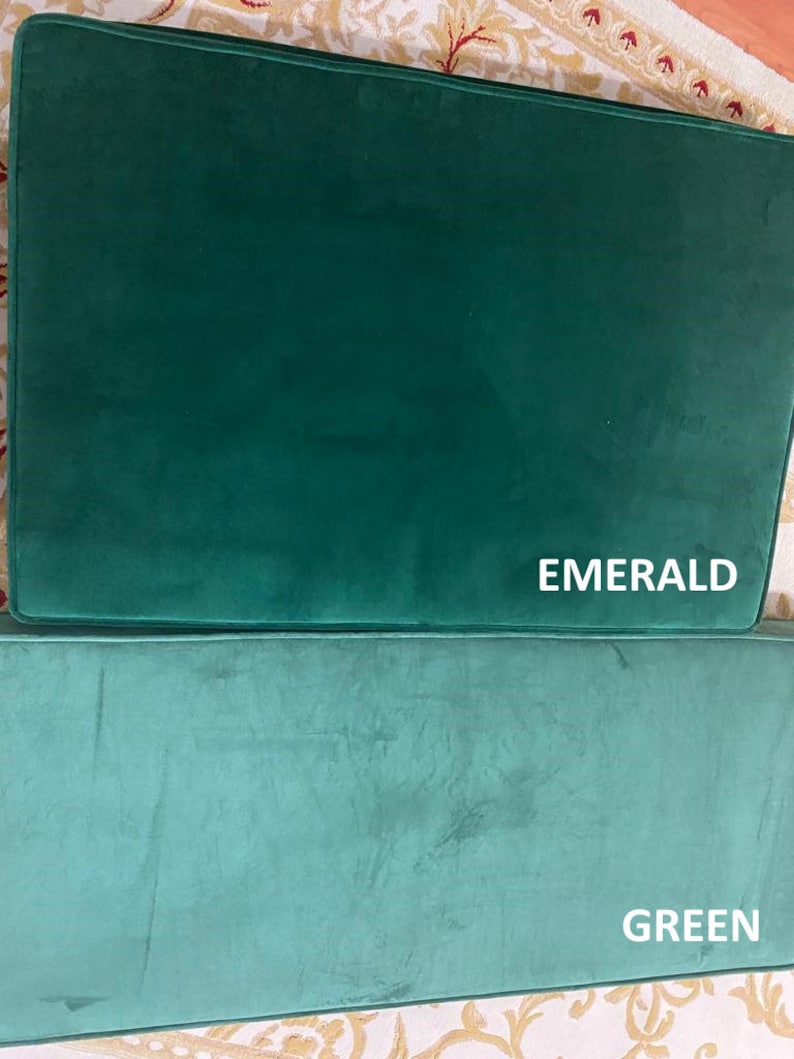 May include: Two green velvet cushions, one labelled "EMERALD" and the other "GREEN".
