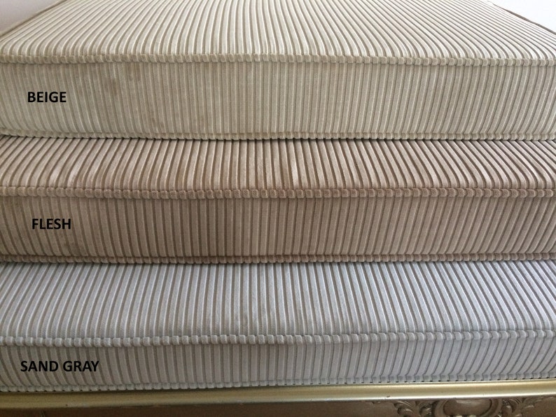 May include: Three corduroy fabric samples in beige, flesh, and sand gray colors. The fabric has a vertical ribbed texture.