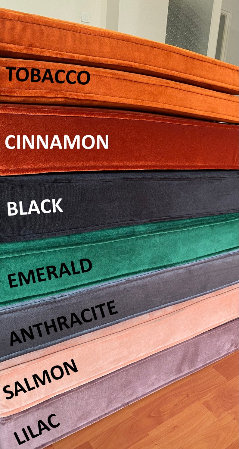 May include: A stack of seven fabric swatches in various colours, including lilac, salmon, anthracite, emerald, black, cinnamon, and tobacco. Each swatch has the colour name printed on it.