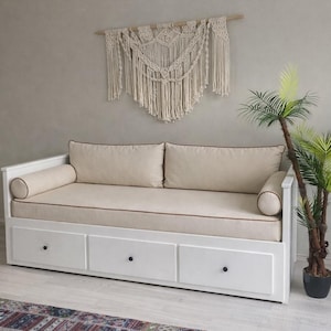 May include: A white ceramic mug with a black handle and the text "But First, Coffee" in a black, handwritten-style font. The mug is on a white surface.