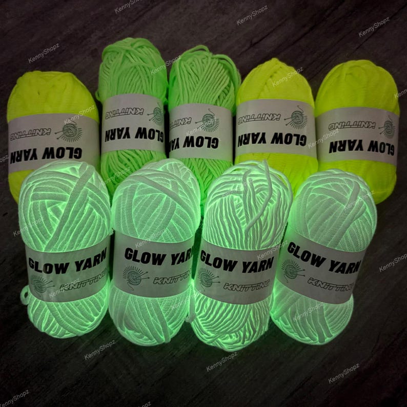 May include: Eight skeins of glow-in-the-dark yarn arranged in two rows. The top row features four skeins of neon yellow yarn, while the bottom row displays four skeins of white yarn. Each skein has a white paper label printed with GLOW YARN.