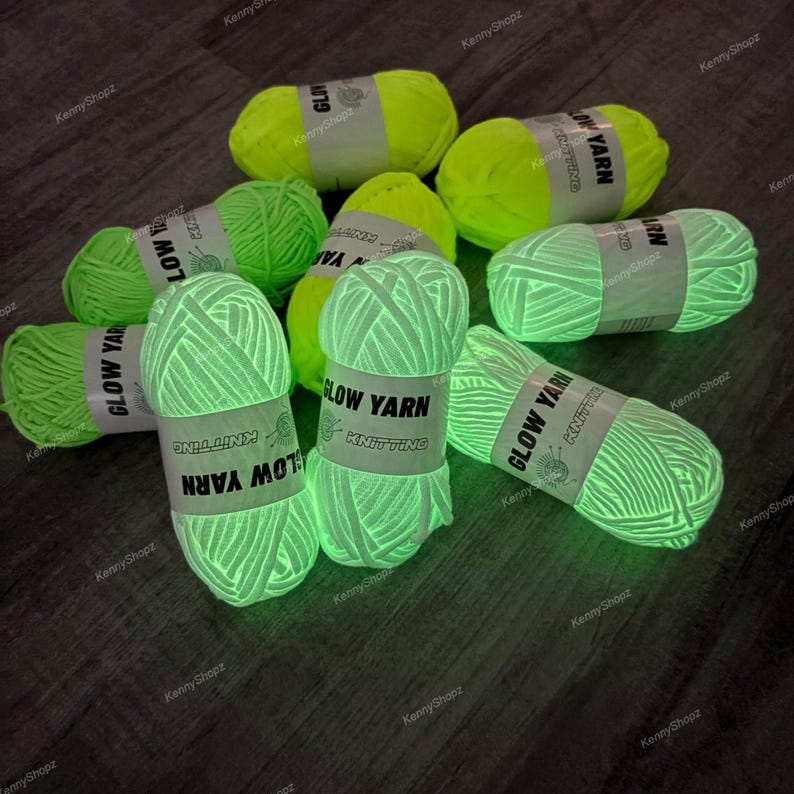 May include: A collection of neon yellow yarn skeins that glow in the dark. Each skein is wrapped in a white paper band featuring the black text GLOW YARN KNITTING. The yarn has a thick, textured appearance and is arranged in a scattered group.