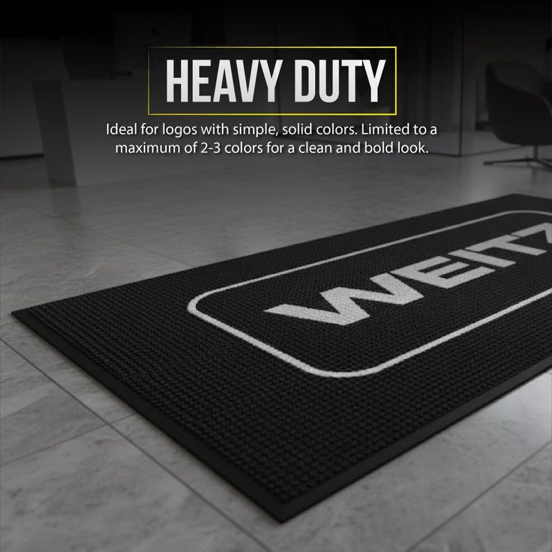 a black and white floor mat with a logo on it, placed on a tiled floor.