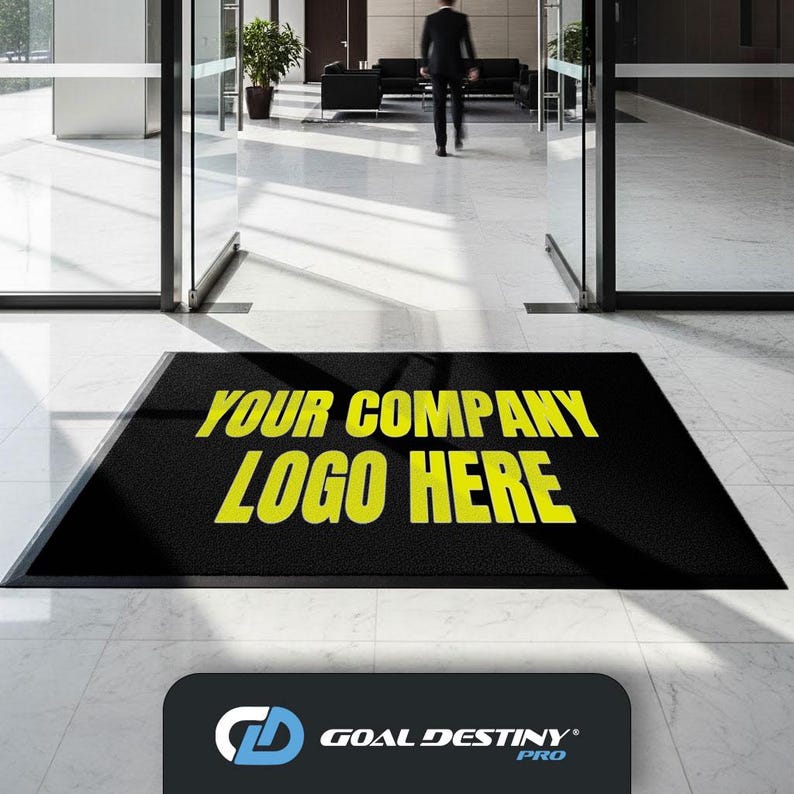 a black mat with the text "YOUR COMPANY LOGO HERE" in yellow letters, placed in front of a glass door.