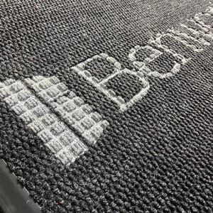 a close up of a rug with a building on it