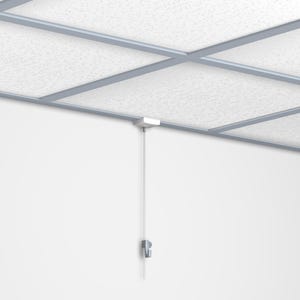 May include: A white ceiling with a grid of gray metal beams. A white square fixture is mounted on the ceiling, with a thin, white cable hanging down to a small, gray metal clip on the wall.
