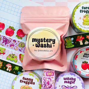 Puede incluir: Una colección de cintas washi decorativas con diseños caprichosos. Las cintas presentan ilustraciones de ranas, setas, mariposas y bayas. El texto en las cintas incluye "Forest Froggies", "Funny Froggies", "Witchy Magic" y "Moody Berries".