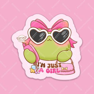 May include: A sticker featuring a cartoon frog wearing heart-shaped sunglasses and a pink bow. The frog is holding a pink purse and has a pink envelope with a heart on it. The text "I'm just a girl" is written below the frog.