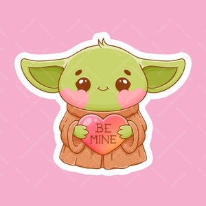 Sticker bébé extraterrestre Be Mine - Adorable extraterrestre vert kawaii avec de grandes oreilles tenant un coeur rose en vinyle imperméable découpé - Sticker brillant