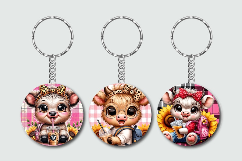 May include: Three keychains with round, colorful, cartoon cow designs. Each cow is wearing a different outfit and holding a different accessory. The keychains are attached to silver key rings.